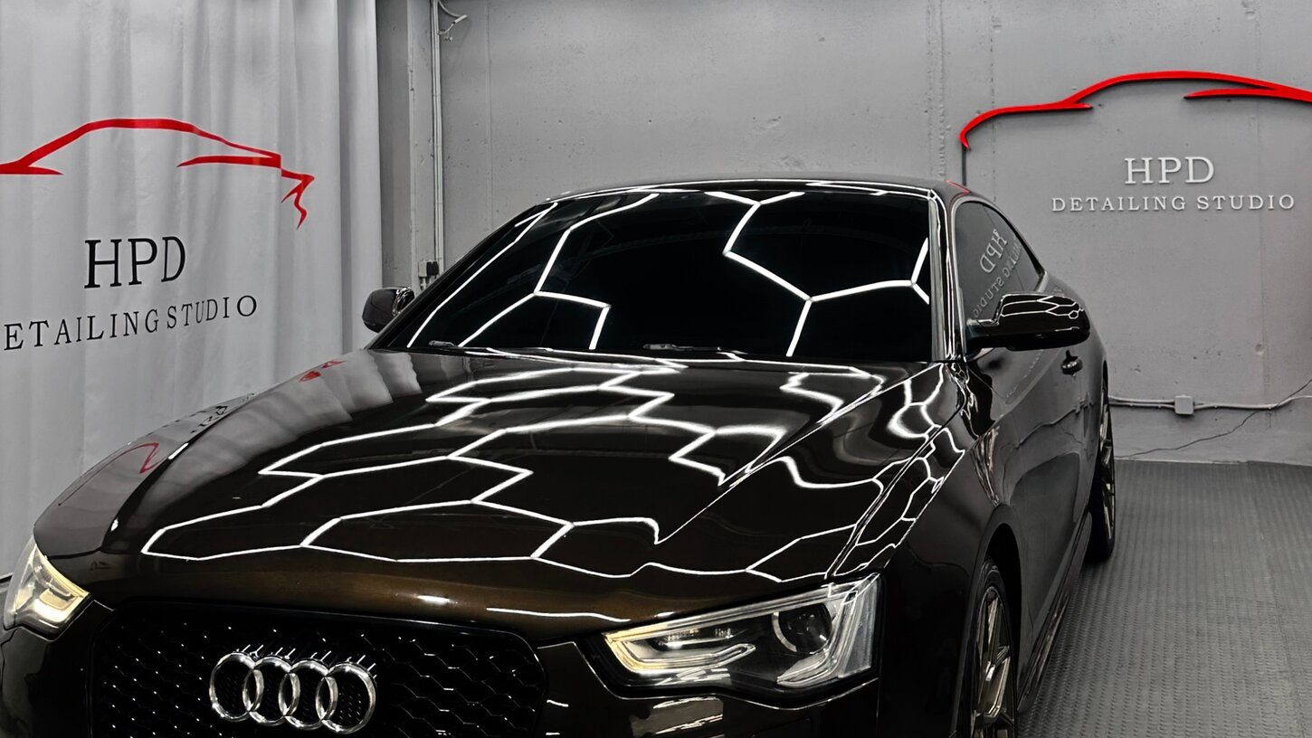 Audi в боксе HPD под шестигранными светильниками — отражения на капоте после полировки